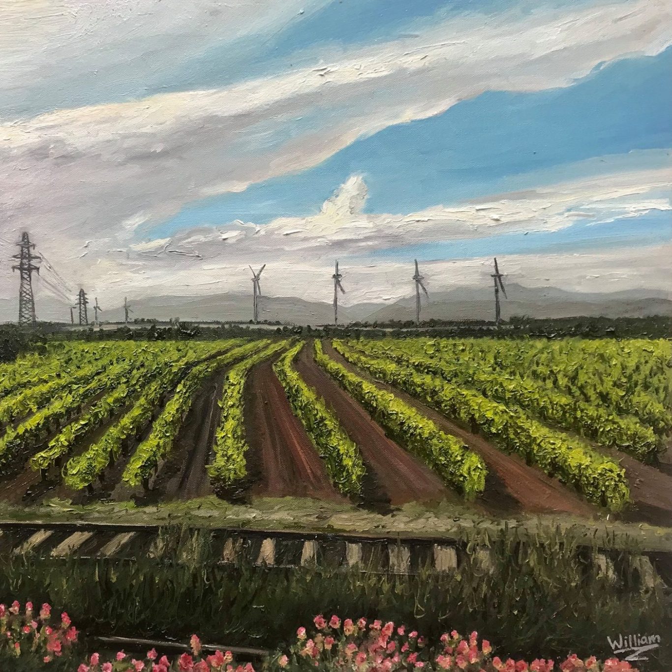 The Pyreness Vineyard landscape with green rows, pink flowers, and wind turbines under a blue sky.