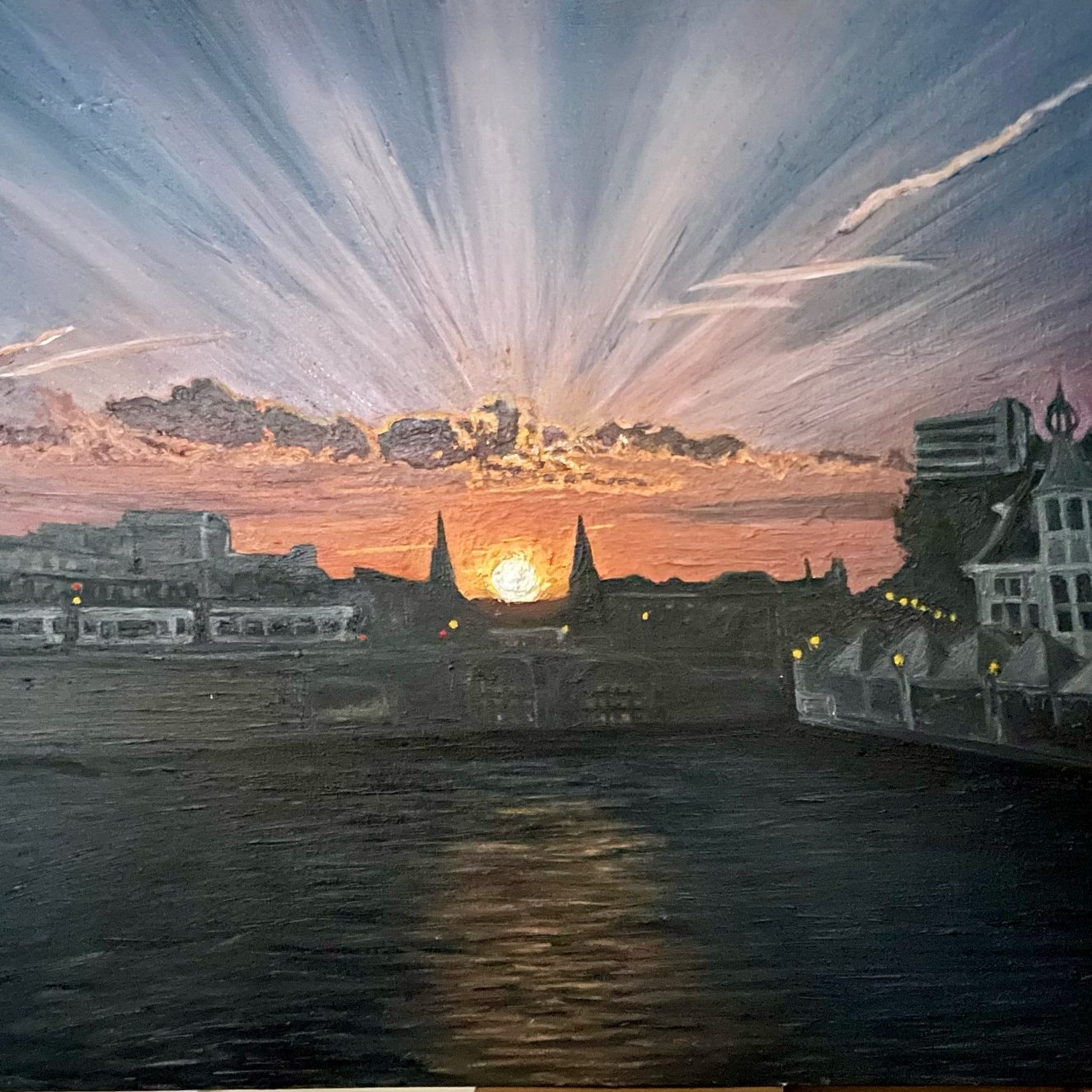 Sunset over a calm sea with boats, framed by coastal hills and sparkling water.